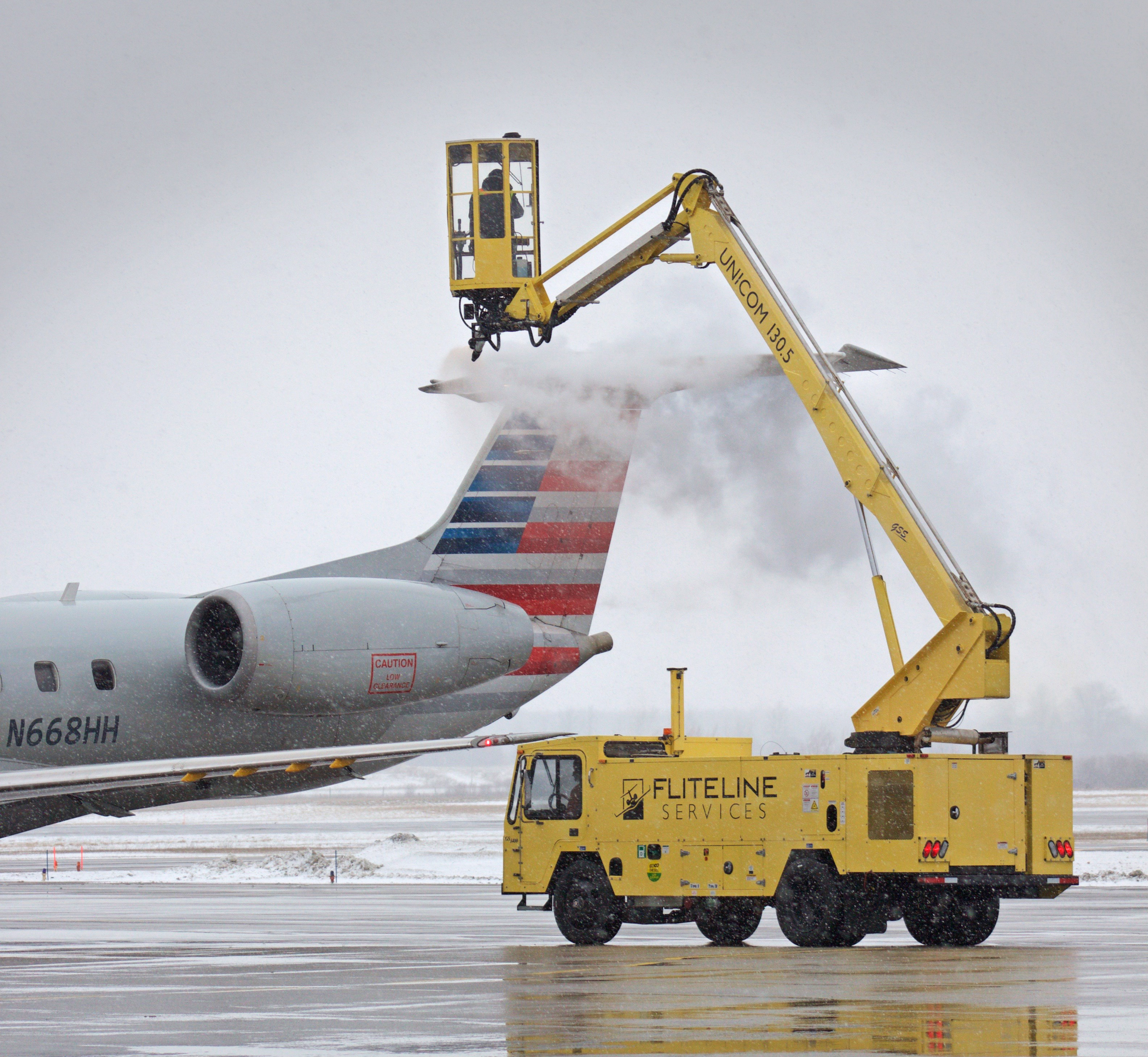 Flite Line Services de-icing truck treating an aircraft in winter conditions